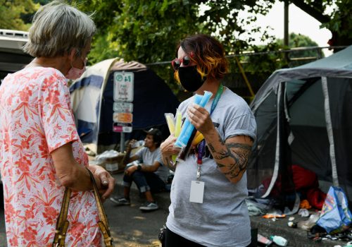 Misty Monroe of Cascadia Behavioral Healthcare distributes popsicles to vulnerable members of the community as a heat wave continues in Portland, Oregon, U.S.