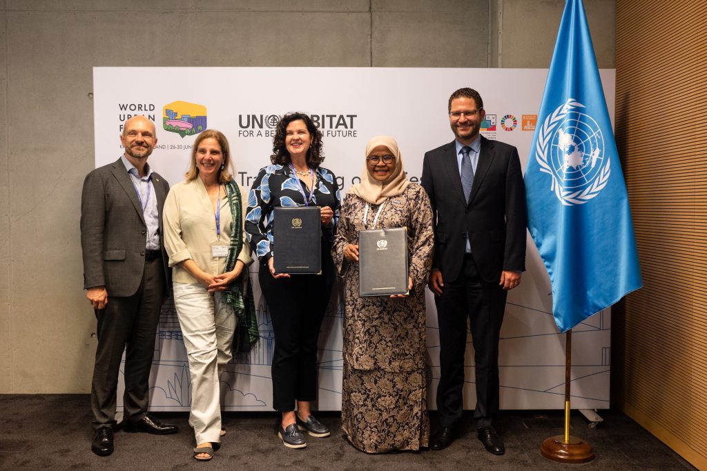 Image of Arsht-Rock team and UN-HABITAT team holding signed MOUs at the World Urban Forum in Katowice, Poland.