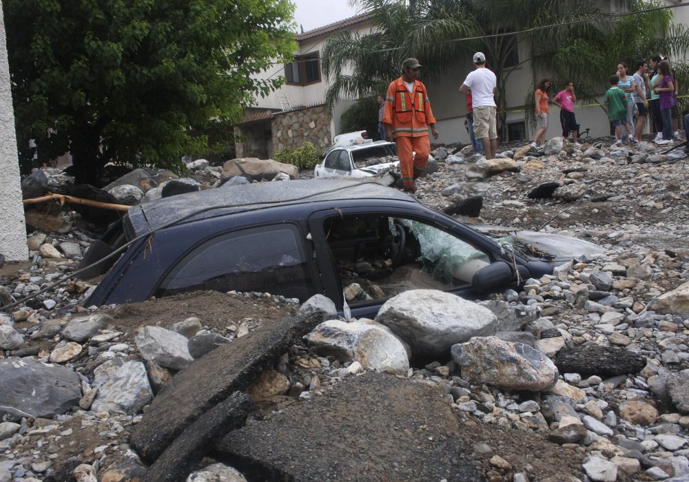 Residents stand outside their homes after a landslide caused by Hurricane Alex hit their neighbourhood in Monterrey July 2, 2010. Intense rain from Hurricane Alex shut down Mexico's Monterrey as floods killed six people, swept away cars and swamped wealthy suburbs with mud and rocks. REUTERS/Kristian Lopez 