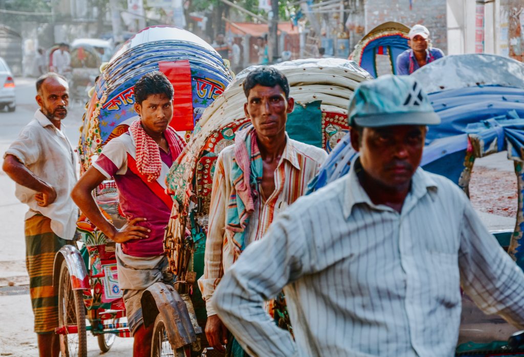 A group of hardworking trishaw operators waiting for customers in Dhaka, Bangladesh. Outdoor workers face great economic burden when temperatures become hot.