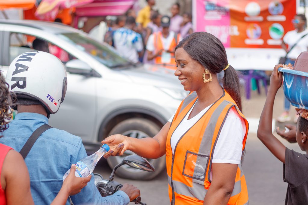 Image of Chief Heat Officer Eugenia Kargbo handing a water bottle to resident during the #BeatTheHeat launch event to help people know how to stay safe during a heat wave.