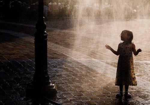 A small girl is cooling by a water sprinkler at the Podgorski Square in Krakow, Poland on June 20, 2023. Hot air masses covered the country and thermometers read over 30 degrees Celsius. (Photo by Beata Zawrzel/NurPhoto)NO USE FRANCE
