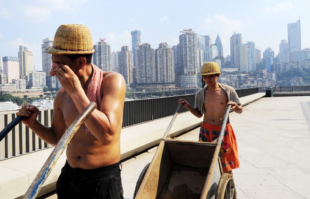 Chinese construction workers push carts under the scorching sunshine in the sweltering weather in Chongqing, China, 30 July 2010.