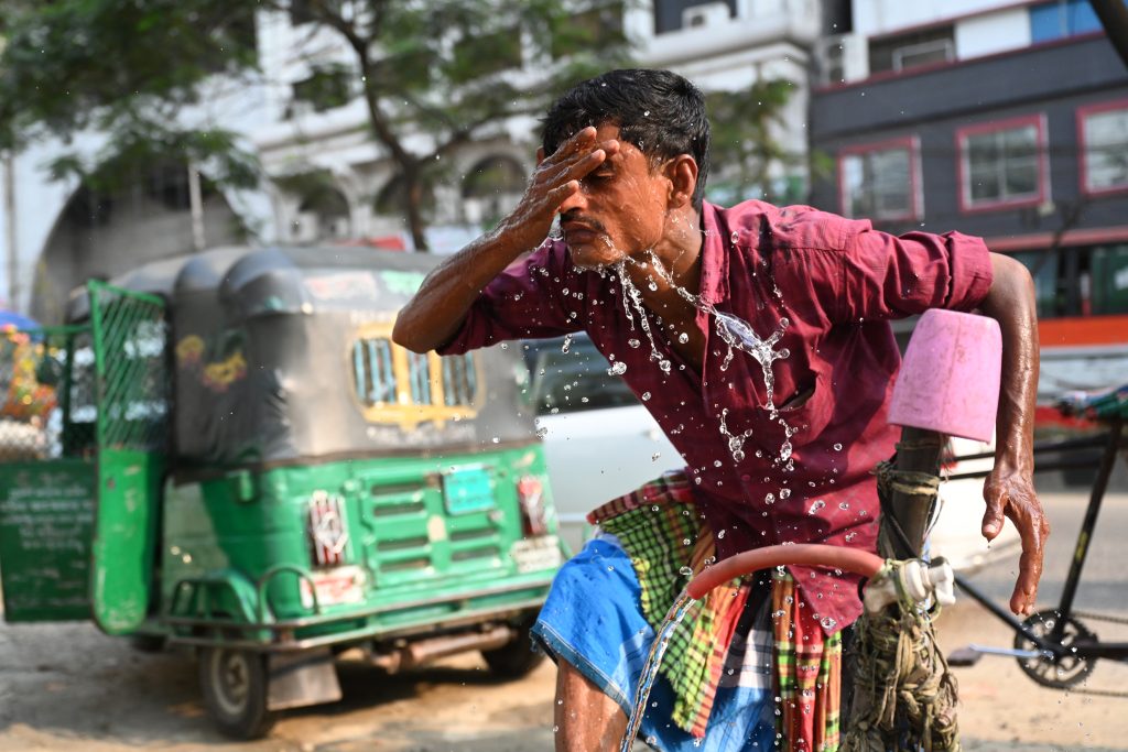 A rickshaw driver is washing his face with water at a roadside water pipeline during a high-temperature day in Dhaka, Bangladesh, on April 15, 2024. (Photo by Mamunur Rashid/NurPhoto)NO USE FRANCE