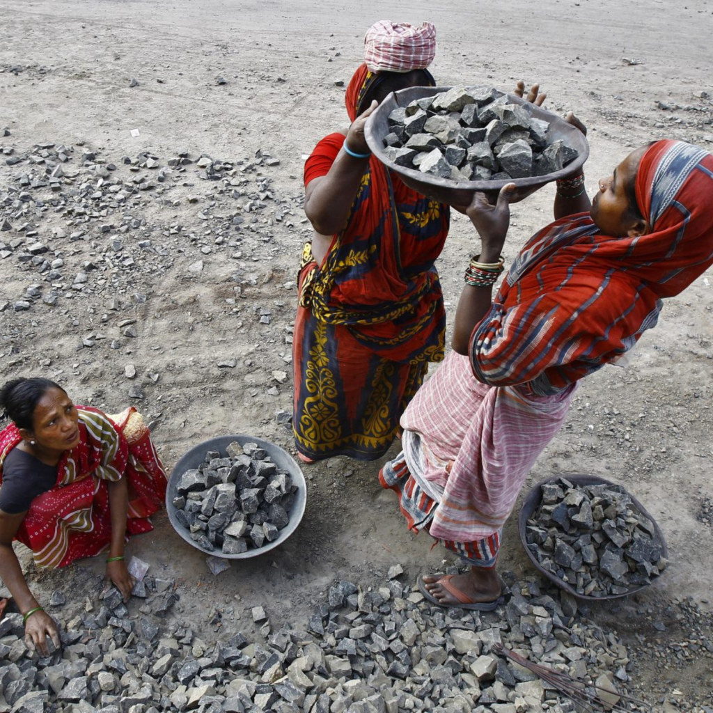 Three women working in a stone quarry.