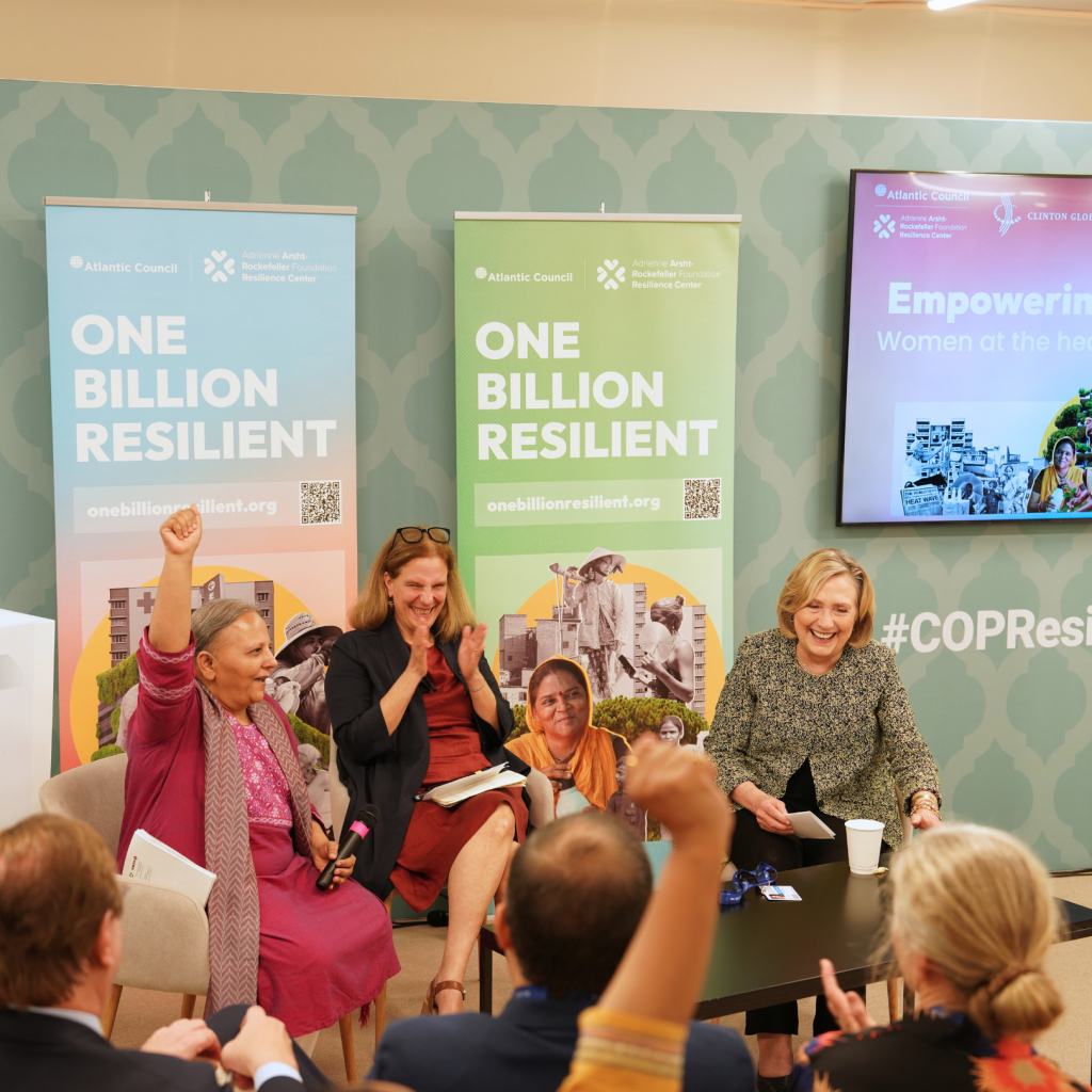 Image of Reema Nanavaty, Eleni Myrivili, and Secretary Clinton speaking at the COP28 Resilience Hub.