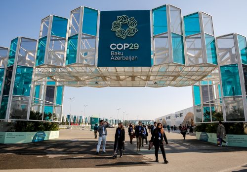 Participants walk by an entrance of COP29, UN Climate Change Conference venue, an event held by UNFCCC in Baku Olympic Stadium in Baku, the capital of Azerbaijan on November 10, 2024. COP29, running from November 11-22 focuses on carbon offset procedure and Loss and Damage Fund.