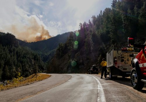 Photo of firefighter monitoring a California fire. The smoke plume resulted after the fire spread across 8,000 acres within the first 5 hours.