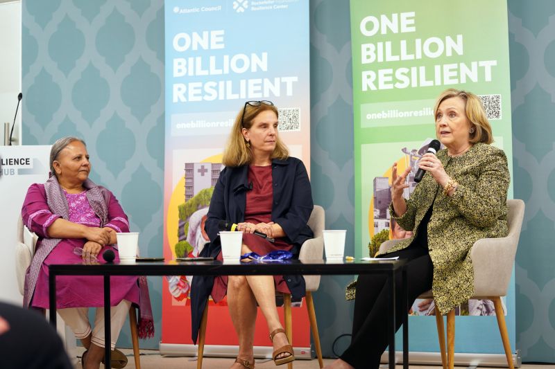 Image of Reema Nanavaty, Eleni Myrivili, and Secretary Hillary Clinton seated on stage at COP28.