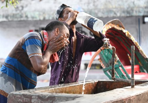 A rickshaw driver is washing his face with water from a roadside water pipeline during a heatwave in Dhaka, Bangladesh.