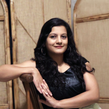 Apekshita Varshney sitting, looking to camera.